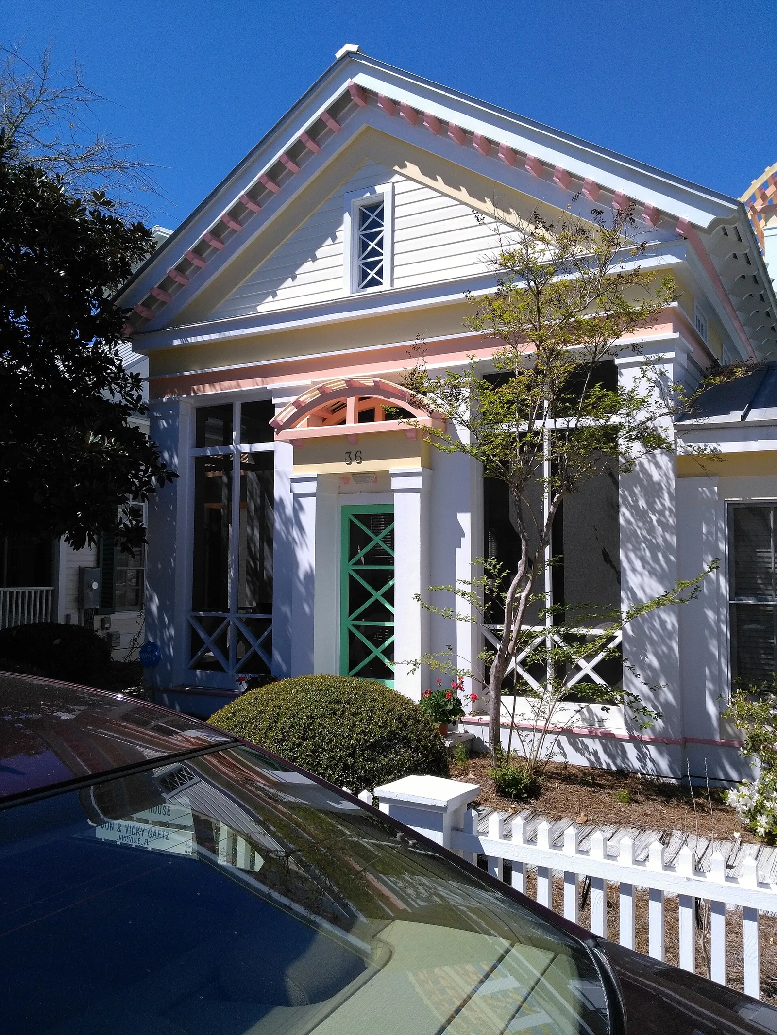 White house with pink and green trim and a white picket fence, used as Truman Burbank's home in The Truman Show