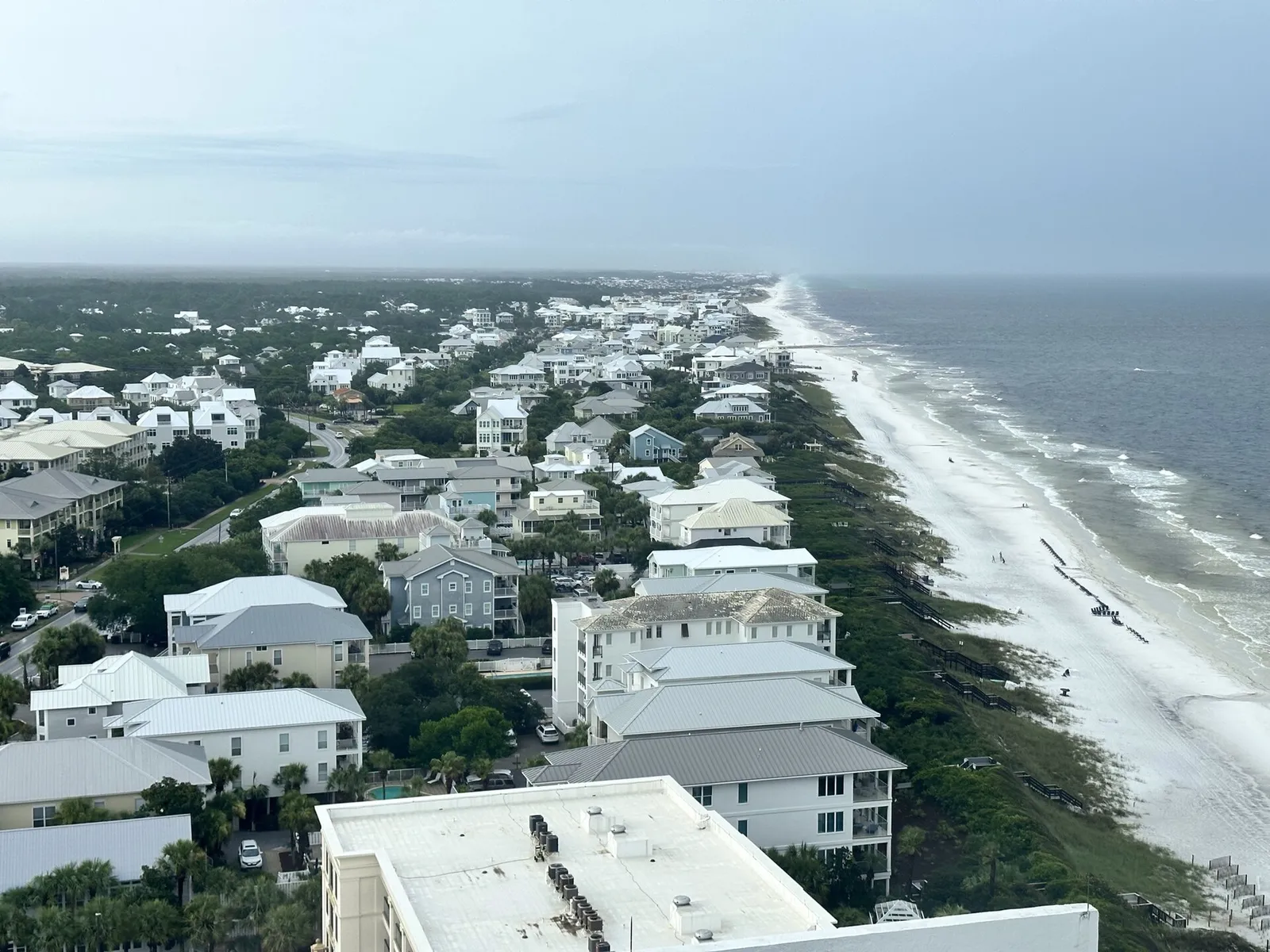 Elevated view of beach houses, green dunes and white sand stretching along the Gulf at Seagrove Beach on Scenic 30A