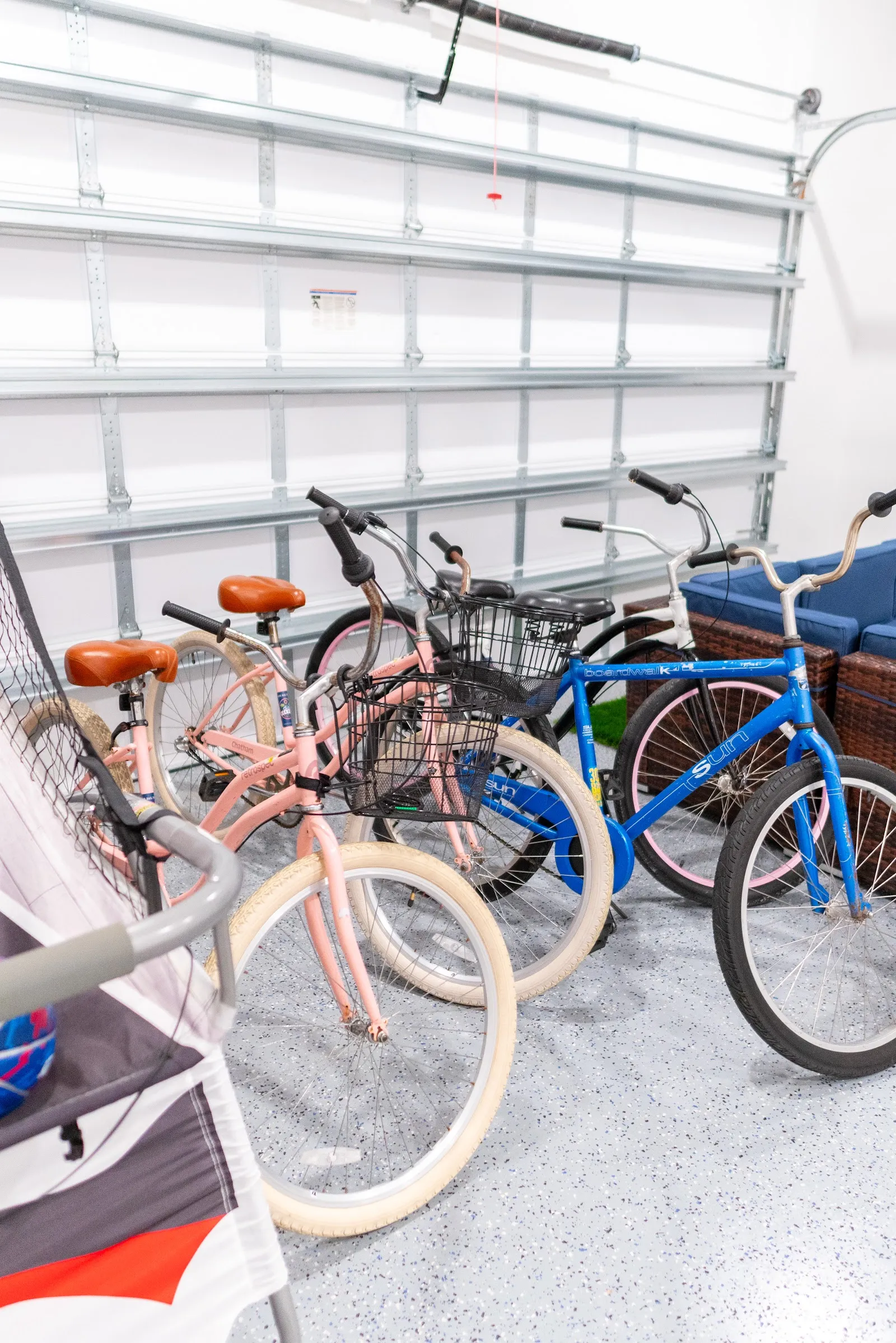 Beach cruiser bikes with baskets lined up inside a bright garage, ready to ride